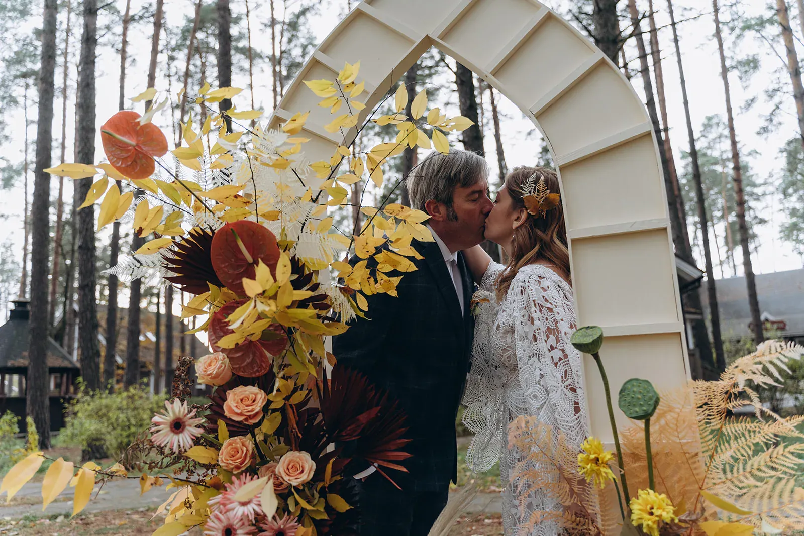 William and Lilia sharing a kiss outdoors on their wedding day.